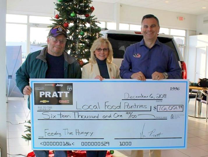 Three individuals proudly display a large check