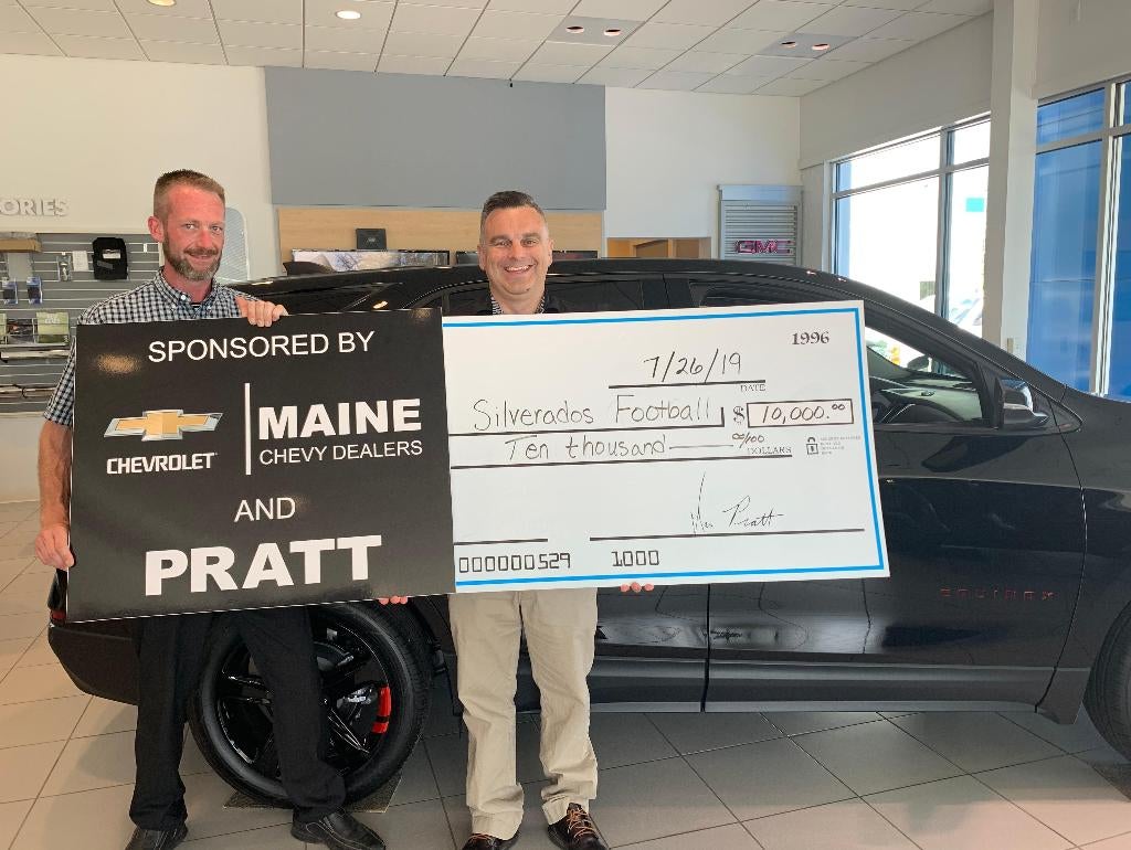 Two individuals proudly display a large check